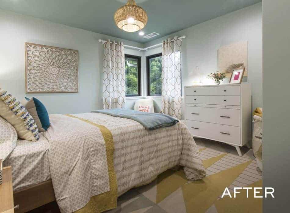 Renovated bedroom with blue walls, a woven light fixture, and a patterned rug