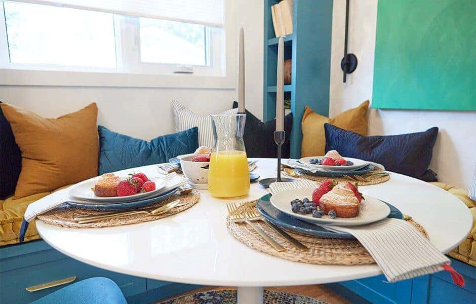 Cozy breakfast nook with a round white table and built-in bench seating