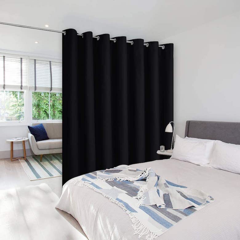 Bedroom with black curtain room divider