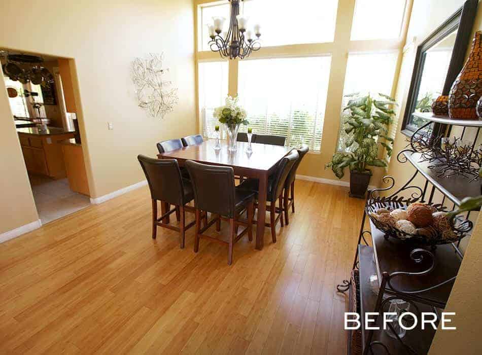 Traditional dining room with a dark wooden table, leather chairs, tall windows, and decorative plants