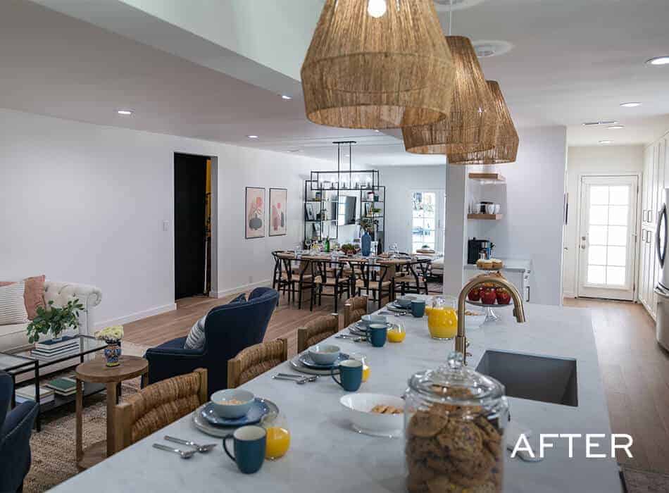Modern kitchen and dining room with white cabinets, quartz countertop, wooden table, chairs, and unique changeliers