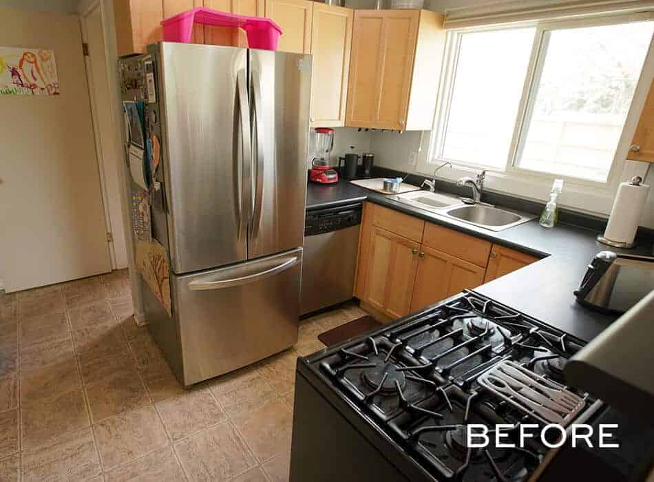 Compact kitchen with black countertops, wooden cabinets, and stainless steel appliances