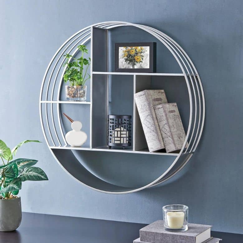 Round wall shelf with decor items against a blue wall
