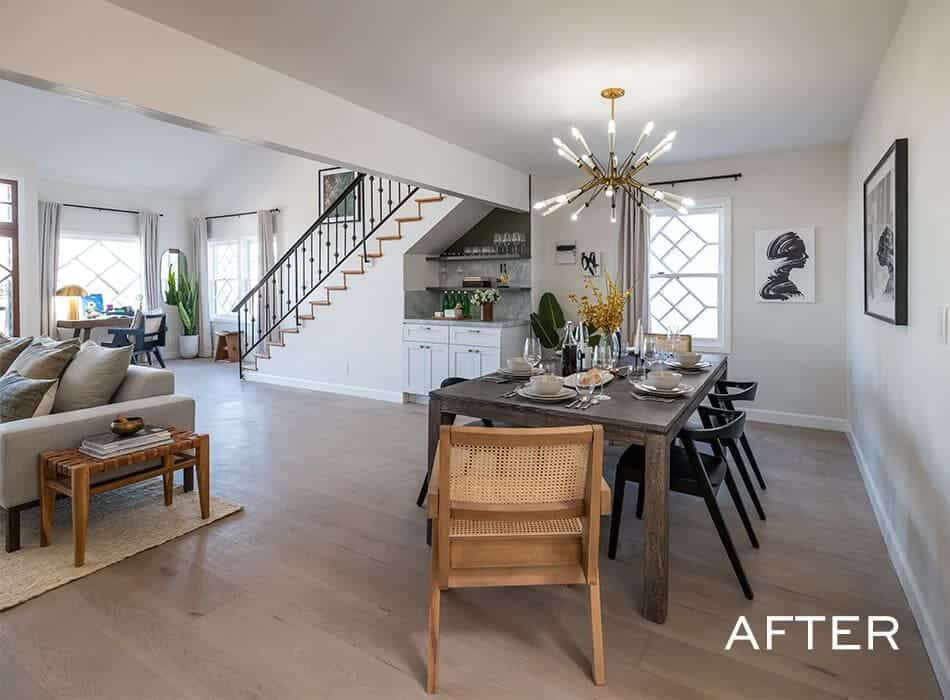 Modern dining and living area with a rustic wood table, black chairs, and a stylish chandelier