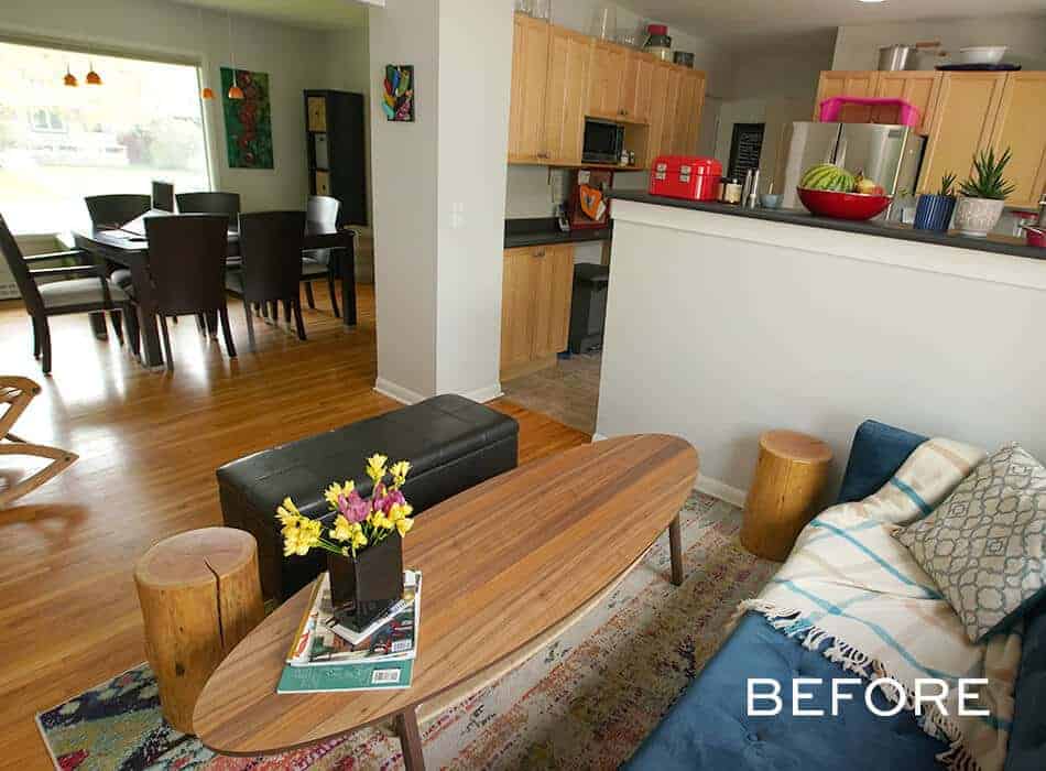 Living room with a blue sofa, wooden table, and kitchen in the background