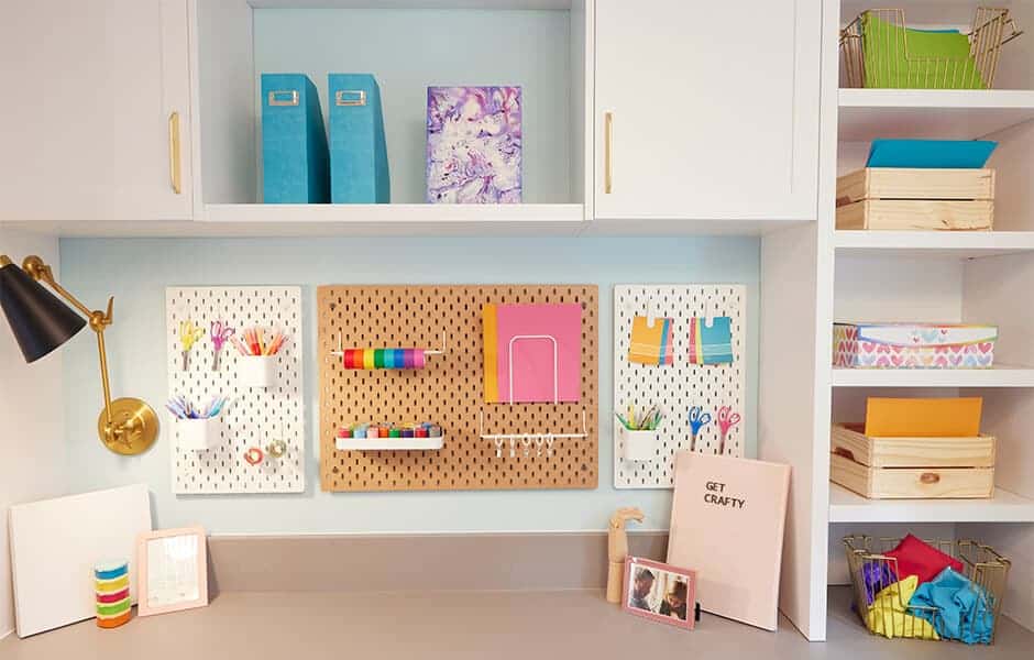 Colorful craft station with pegboard organizers, storage shelves, and art supplies