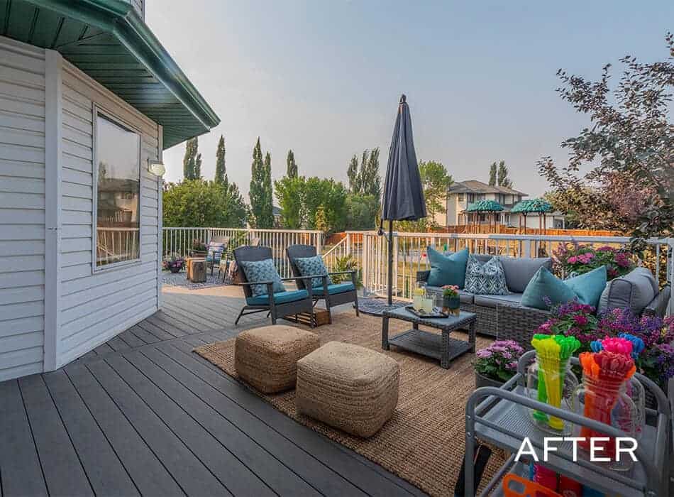 Outdoor patio with wicker furniture, a large umbrella, colorful cushions, and flowers, creating a cozy seating area