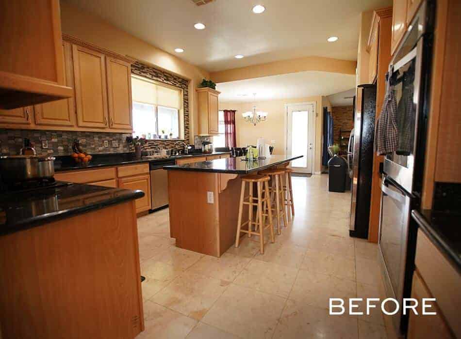 Traditional kitchen with wooden cabinets, black countertops, a central island, and tiled backsplash
