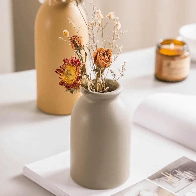 Minimalist beige vase with dried flowers, perfect for a cozy and warm decor accent