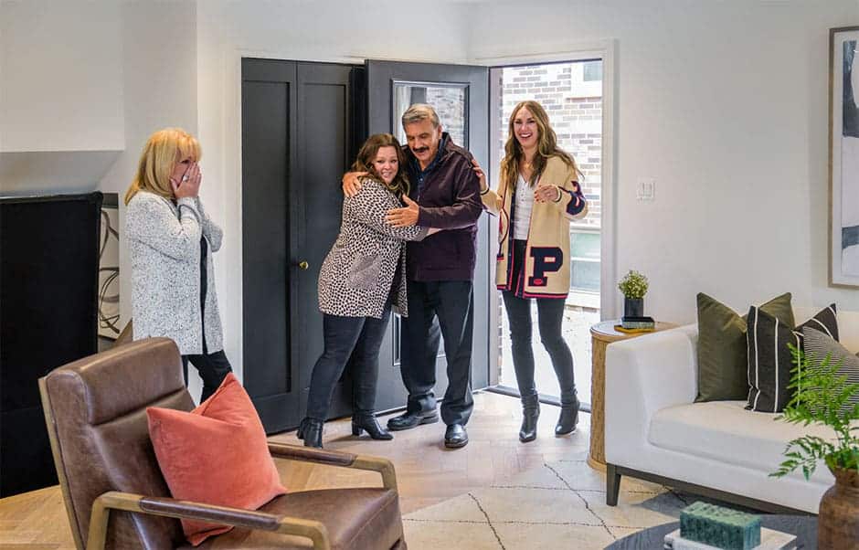 Happy family entering a newly renovated living room, reacting with excitement and surprise