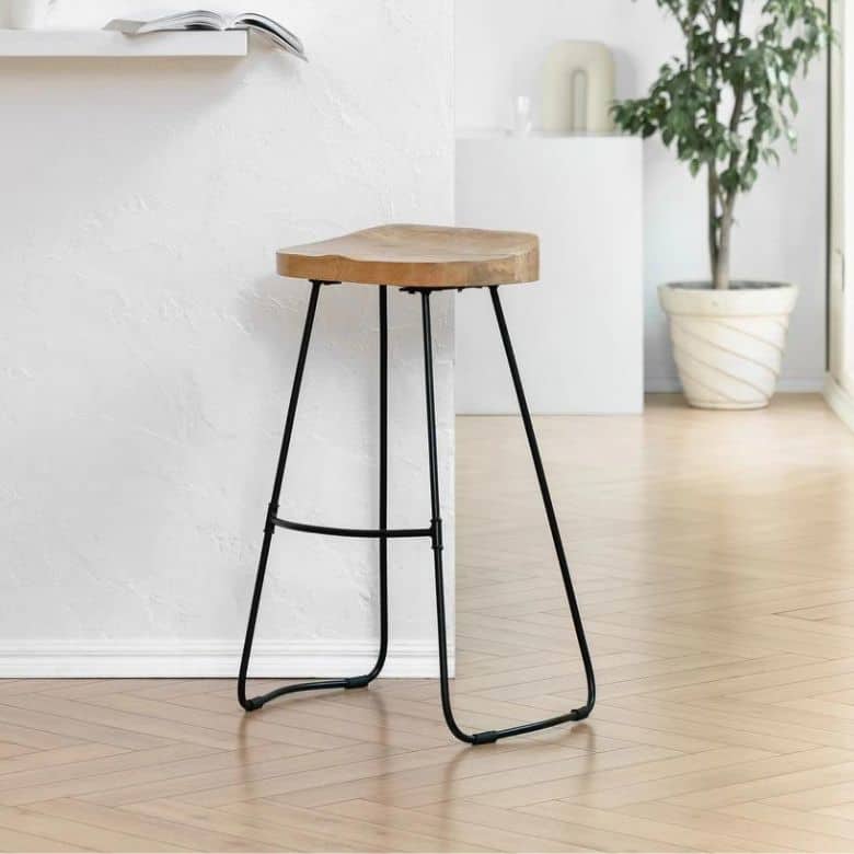 A counter stool with a curved wooden seat and a black metal frame